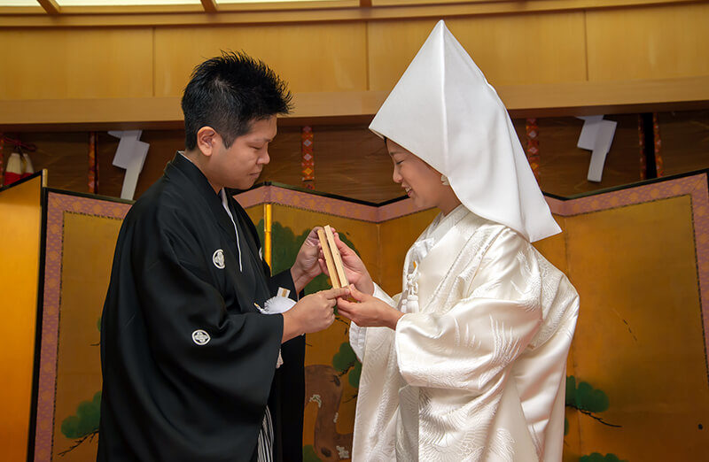 2018年12月、芝大神宮で式を挙げた倫尚さん・茉由子さんのご夫婦。「なくなってしまうかもしれない結婚式用のチャペルより、ずっとそこにある神社ならいつでもふたりで行けるから」と、神社での神前結婚式が希望だったそう。そして一番のこだわりは、ゲストに美味しいお料理を食べていただきたいという思い。そこでふたりは、神社での結婚式をサポートしてくれる会場をいくつか訪ね、すべての会場で料理を試食してチェック。そのなかで一番美味しかったと選んだ会場が、浜松町の世界貿易センタービルの高層階にあり、近隣の古社「芝大神宮」での挙式が可能な「PENTHOUSE THE TOKYO スカイホール」でした。
