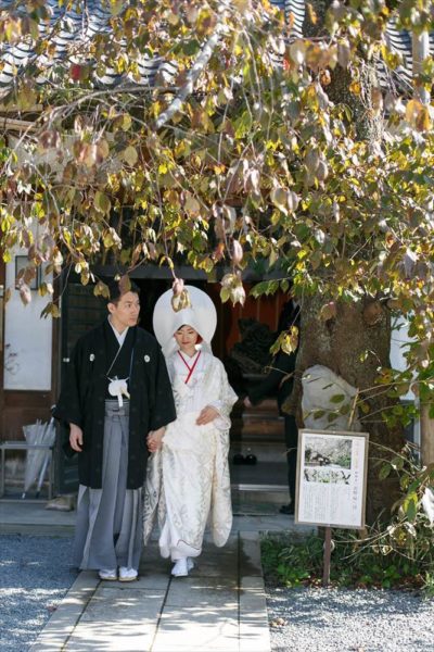 北野天満宮での結婚式は、本殿と紅梅殿で行うことができます。
ふたりが選んだのは「紅梅殿」での挙式。
事前に見学した際に、本殿ほど人通りが多くなく、静かで落ち着いた佇まいと周囲を流れる綺麗な水や庭園が気に入って選んだそう。
定刻、控室で親族紹介を終えた両家の親族と新郎新婦一同は、紅梅殿へと境内を進みます。
「一般の参拝者の方々から、口々にお祝いの言葉をかけていただいたのが印象的でした」(新郎)