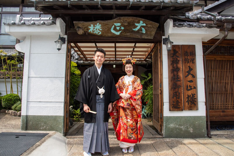 百年以上の歴史を誇る料理旅館「大正楼」。風情のある門がゲストを迎えます。写真撮影をしながら披露宴開宴までの時間を楽しんだふたり。