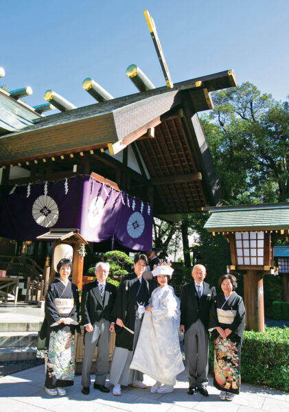 結婚式は、家族と喜びを共にし、ひとつの儀式として執り行いたいと考えていたふたり。歌舞伎観劇を好む新婦と、実家が雛具の会社を経営していた新郎は、着物に親しんでいることもあり、迷わず神前式を希望しました。神社仏閣にも精通している新婦が、日頃から参拝していた神社が「東京大神宮」。都心にあるコンパクトな神社ながら威厳に満ちた雰囲気、美しい祝婚歌の調べで舞う「豊寿舞」などの貴重な儀式も、この神社での神前結婚式を決めたポイントに。
披露宴は、両家の両親との小さな祝宴でしたが、定番のケーキ入刀や水合わせの儀、またお色直しも行い、家族だけの食事会にとどまらない演出も新郎新婦のこだわり。両親たちからのスピーチではふたりの幼い頃からの思い出が語られ、新婦母によるサプライズ演奏もあって、笑みが絶えないアットホームなひとときを叶えることができました。