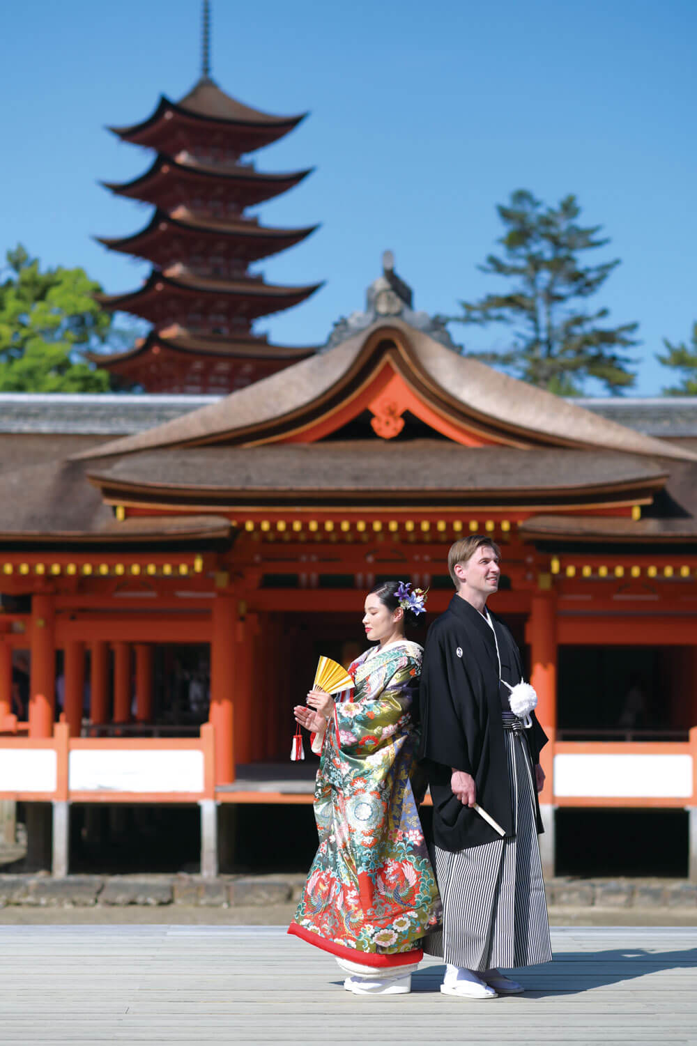 オランダ関係者が集まる新年会で出会ったふたり。入籍後に結婚式を行う予定で準備を進めていたが、コロナ禍でオランダからの渡航が制限され、3年越しの挙式となった。新婦は広島県出身。幼い頃から馴染みのある厳島神社で、新郎とその家族に日本ならではの神前式を経験してほしいと、ここでの結婚式を決めた。青い空と海を見渡す境内は、どこも和装が映える撮影スポット。観光客などたくさんの人に見守られる式も、喜びと幸せ溢れるひとときとなった。
